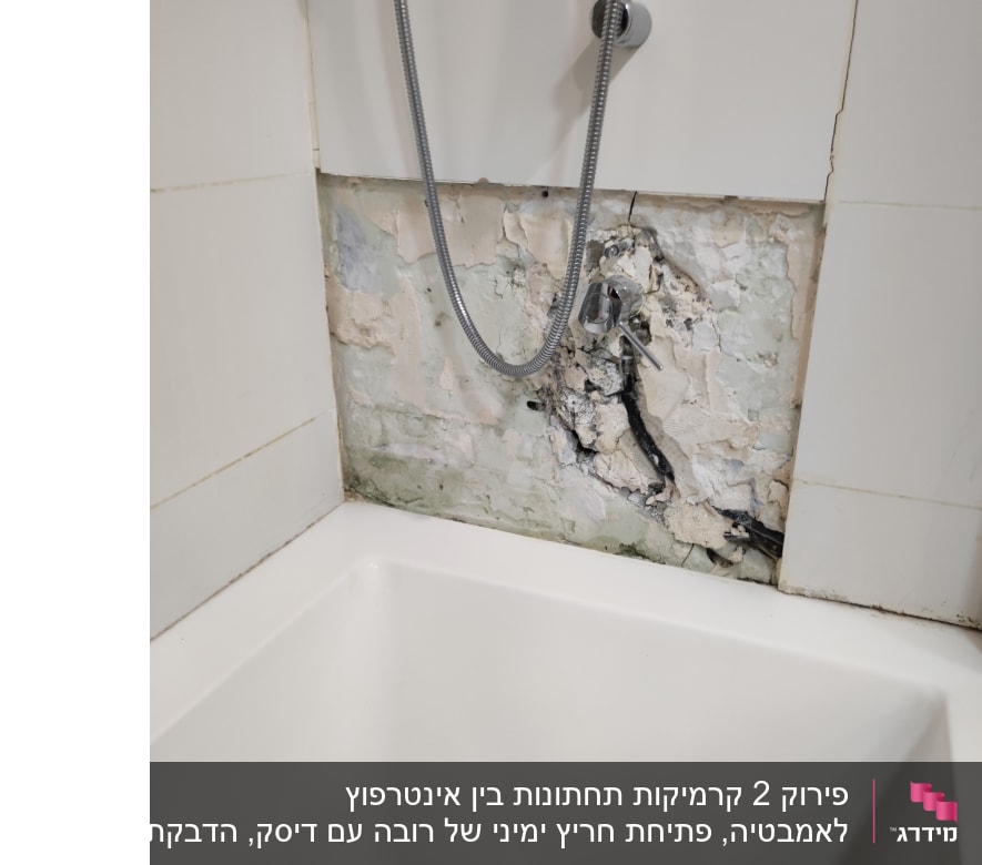 קיר אמבטיה עם אריחים שבורים וצינור מים חשוף
